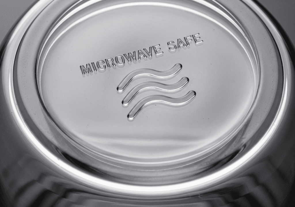 একটি মাইক্রোওয়েভ-সেইফ পাত্রের নিচে থাকা নিরাপত্তা চিহ্ন।